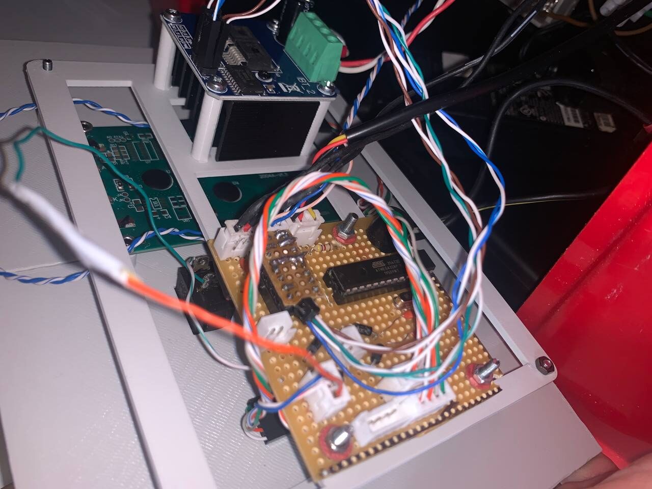 Handgelötete Steuerplatine im offenen Maschinengehäuse: ATmega-Mikrocontroller auf einer Lochrasterplatine, BTS7960B-Motortreiber und ein Gewirr farbiger Kabel