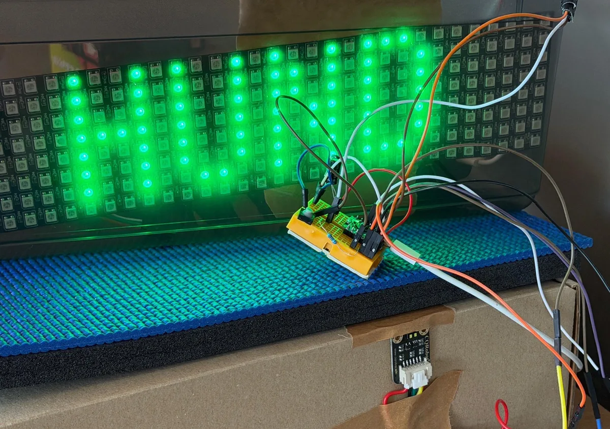 Selbst gebaute Stoppuhr des Robohund-Parcours: LED-Matrix zeigt in grünen Pixeln das Wort HUND, davor Mikrocontroller und Kabel.