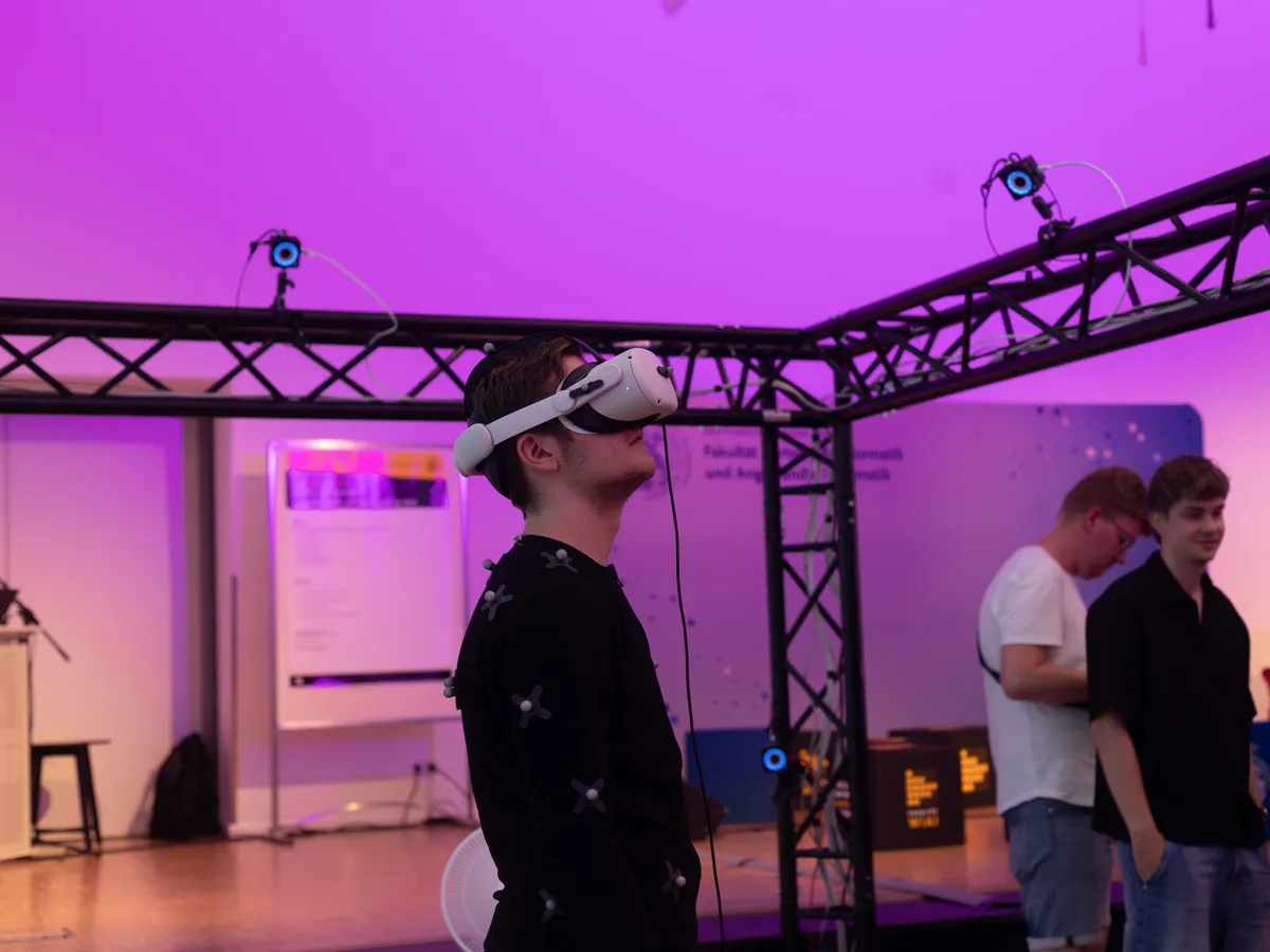 Ein Gast mit VR-Brille steht in einem Traversen-Gestell mit Tracking-Kameras.