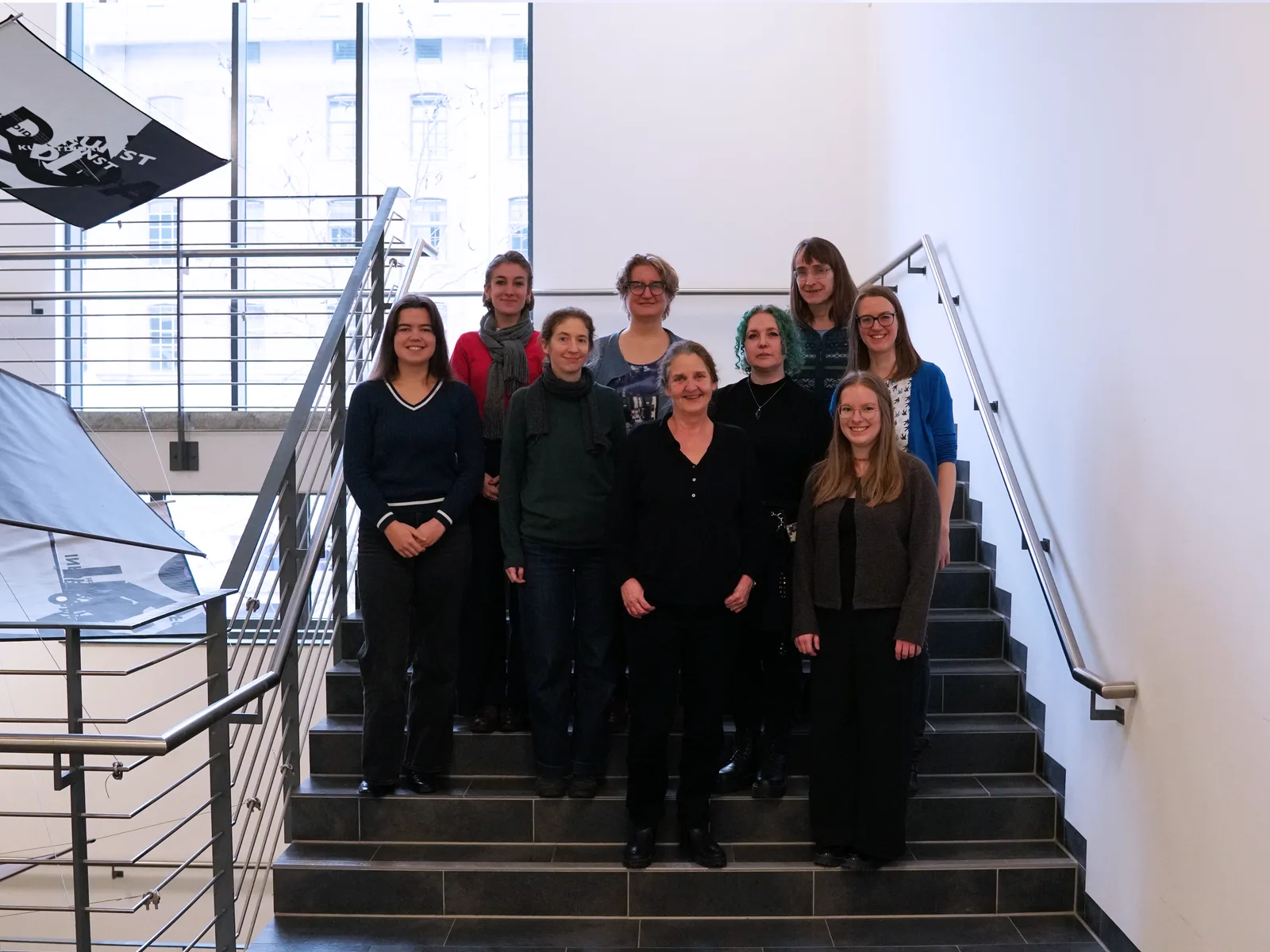Gruppenfoto von rund zehn Frauen des Gleichstellungs-Teams der WIAI auf einer Treppe im Universitätsgebäude